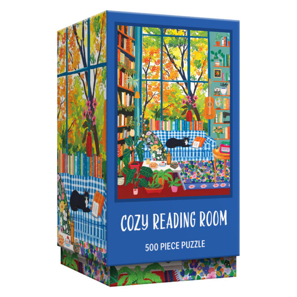 Relax with the ROSEART VERTICAL VISIONS Cozy Reading Room 500 Piece Jigsaw Puzzle, featuring a charming book-filled space, lush plants, a bright window, and a cat lounging on a blue-checked sofa.